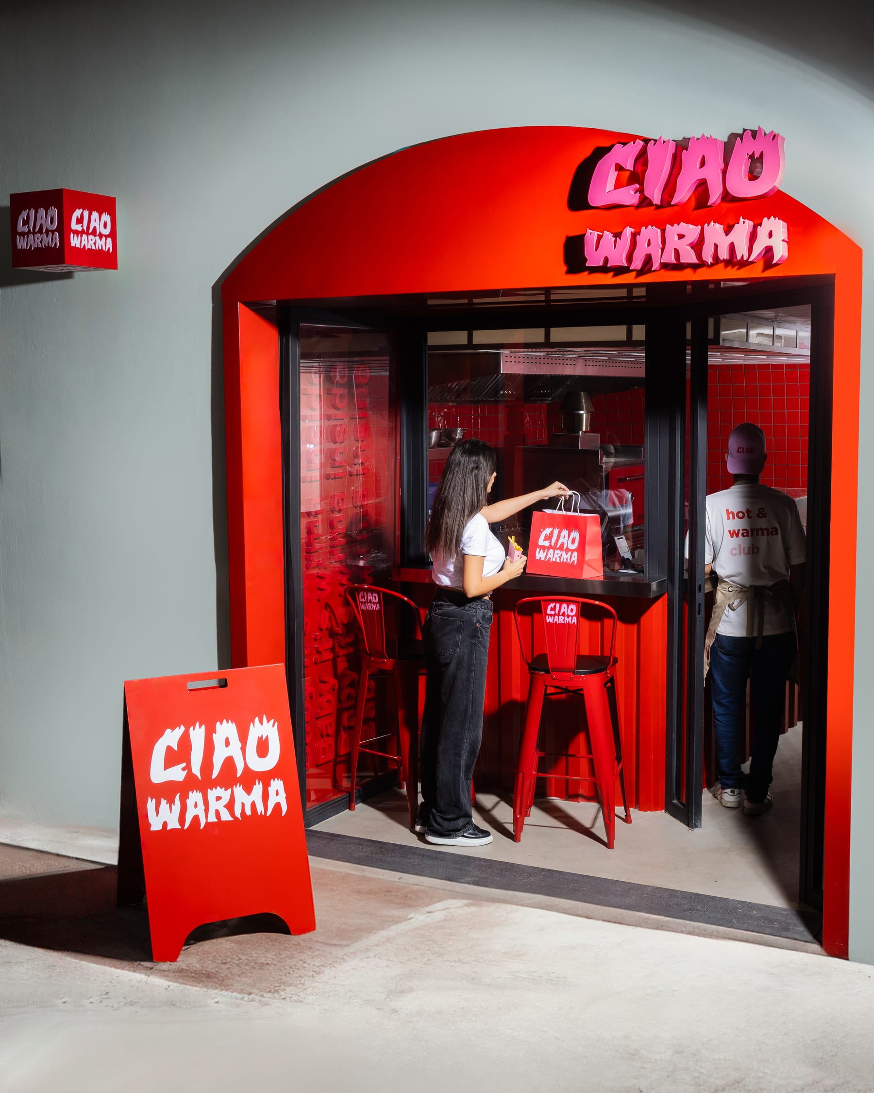 The red-tiled Ciao Warma takeaway counter with its neon sign and pavement A-board, customers ordering inside