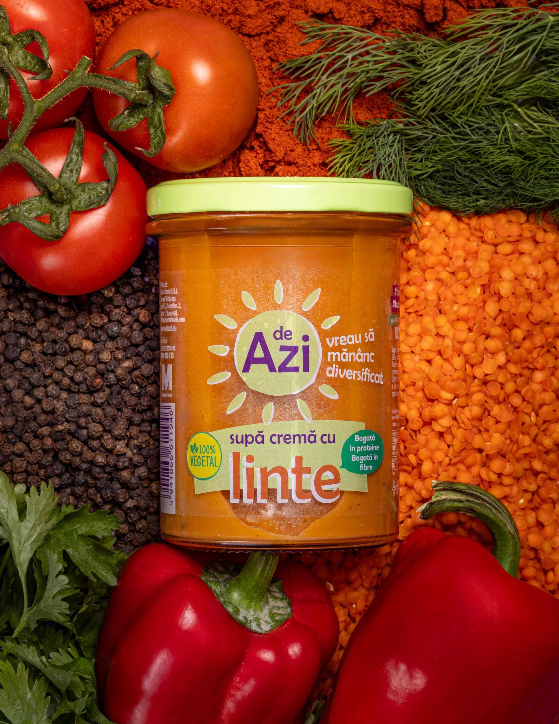 A de Azi lentil soup jar surrounded by tomatoes, red lentils, peppercorns, herbs, and red peppers