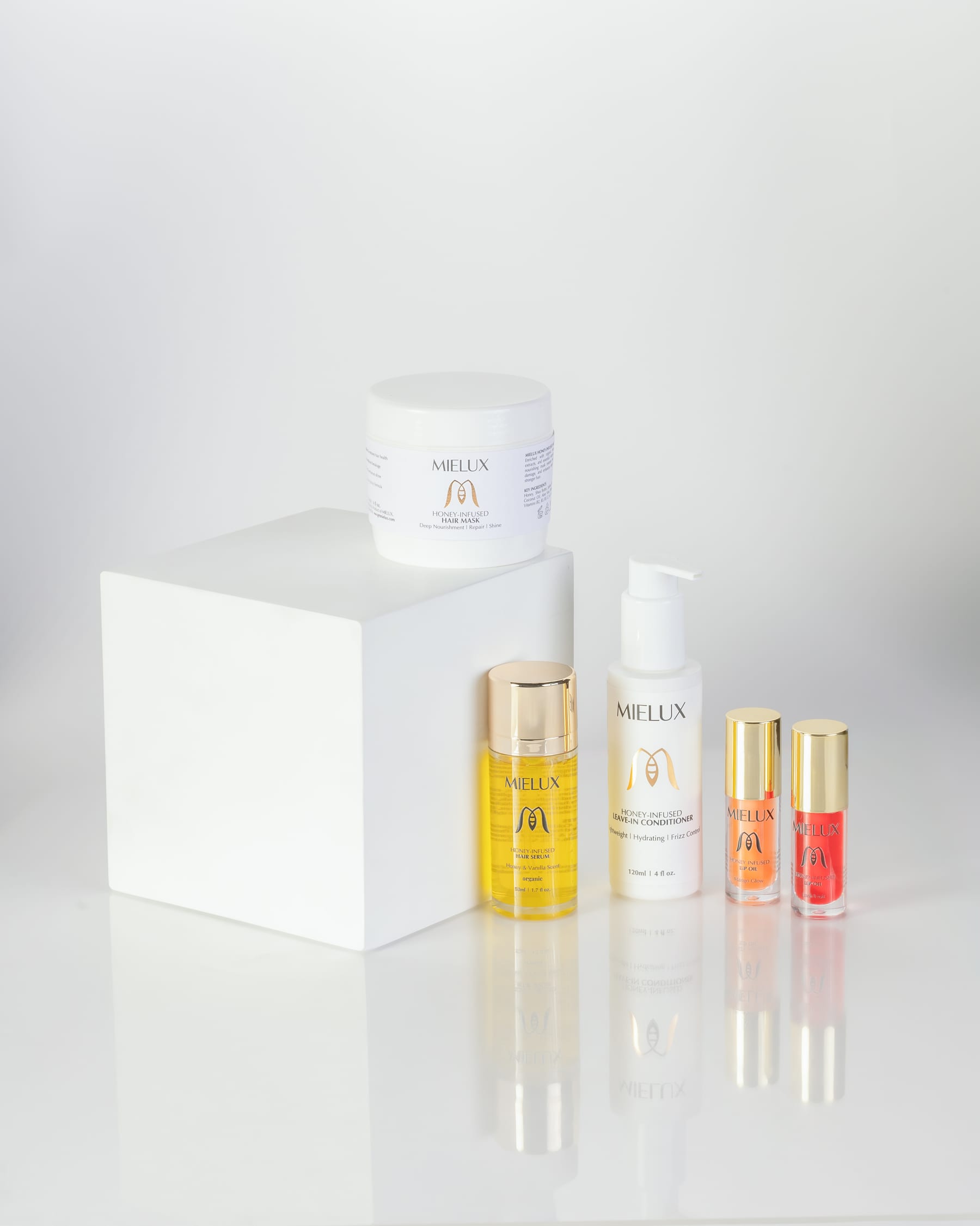 Mielux haircare bottles and jars arranged on a white plinth against a white ground